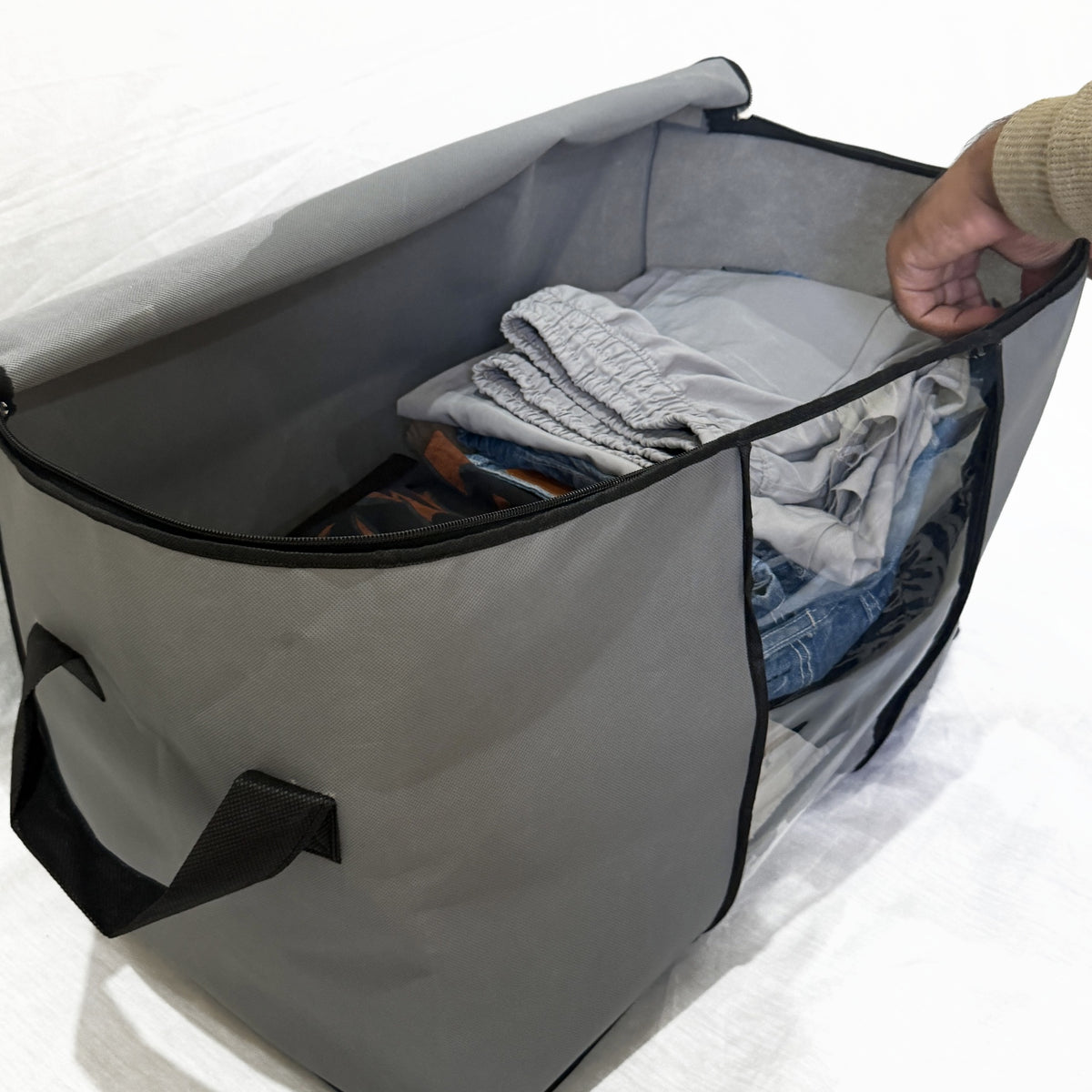 Clothes going into the open bag